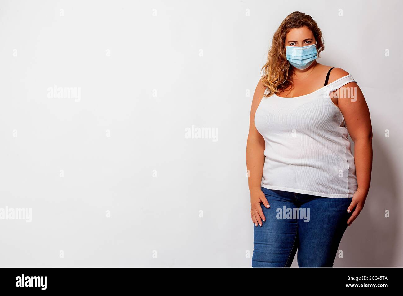 Portrait of a beautiful blonde woman with oversize and face mask Stock Photo