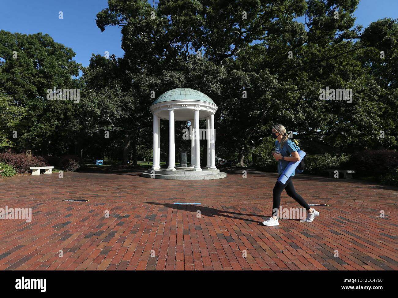 Chapel Hill, North Carolina, USA. 18th Aug, 2020. Freshman MARIA SMITH of Denton, NC walks past the iconic Old Well on the campus of UNC-Chapel Hill. The school will move all undergraduate classes online starting Wednesday, after 130 more students tested positive for the coronavirus. There have been reports of four COVID-19 clusters over three days in dorms, apartments and a fraternity house. Credit: Bob Karp/ZUMA Wire/Alamy Live News Stock Photo