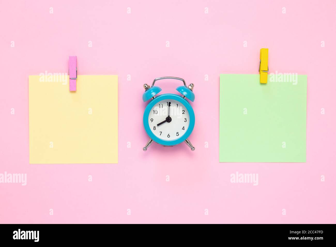 Two blank stickers, planning concept. Place for text, copy space. Note paper with pin and alarm clock. Mockup, bulletin board. The clock shows 8 am Stock Photo