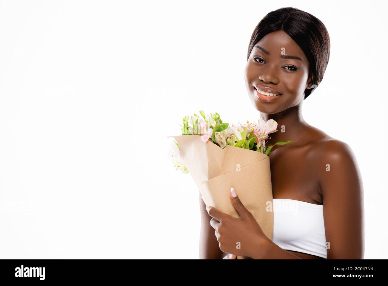 african american woman smiling while holding bouquet of flowers ...