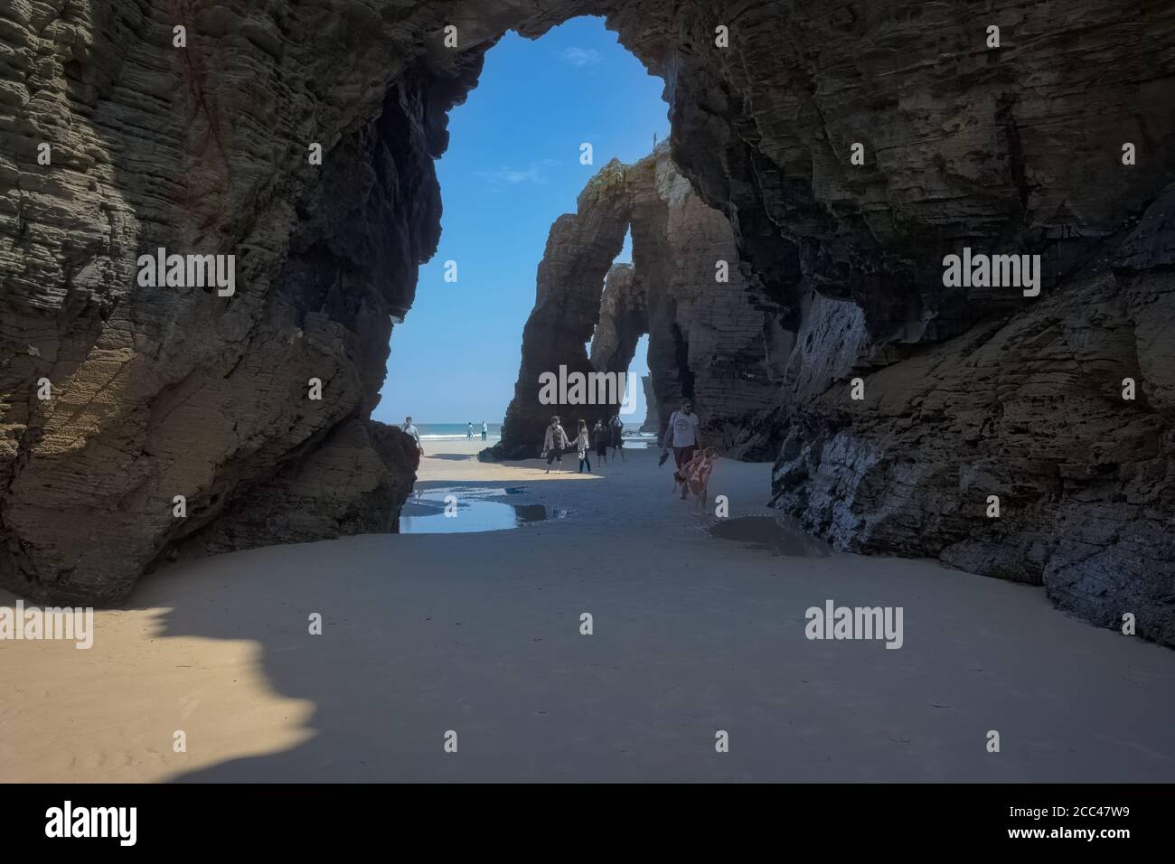 Cathedrals beach, Galicia, Spain - May 2017: View of the set of buttresses on the beach where tourists pass underneath. Stock Photo
