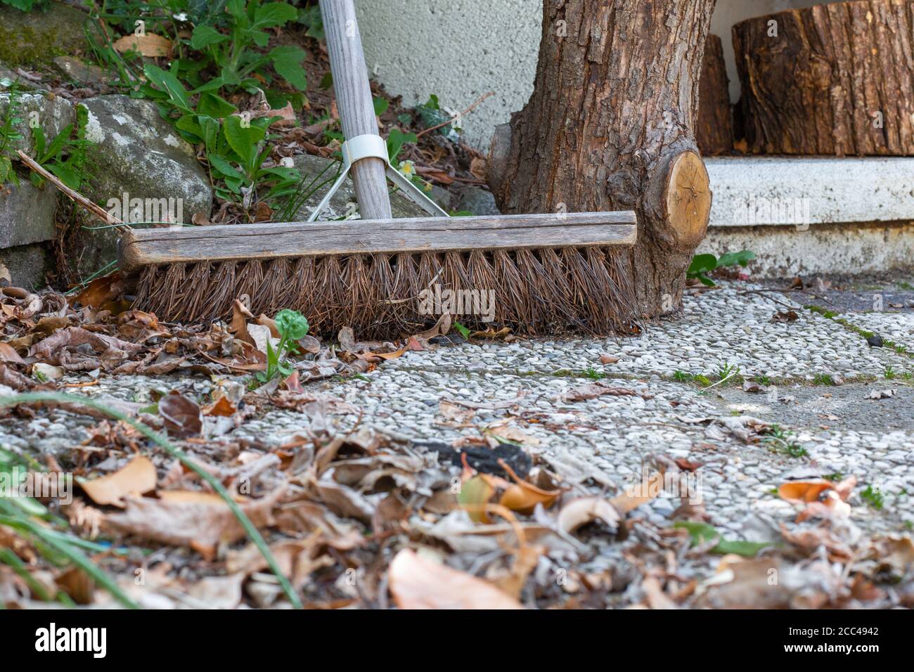 Broom on a terrace with fall leaves. Stock Photo