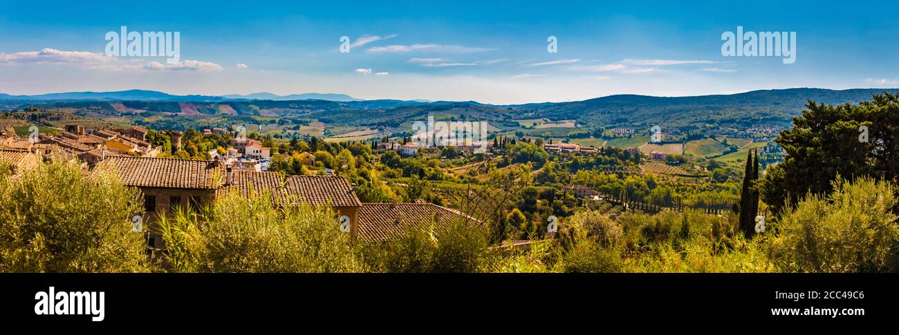 Beautiful panorama picture of the famous medieval town San Gimignano and the lovely countryside. A typical Tuscan landscape with its valleys on a hot... Stock Photo