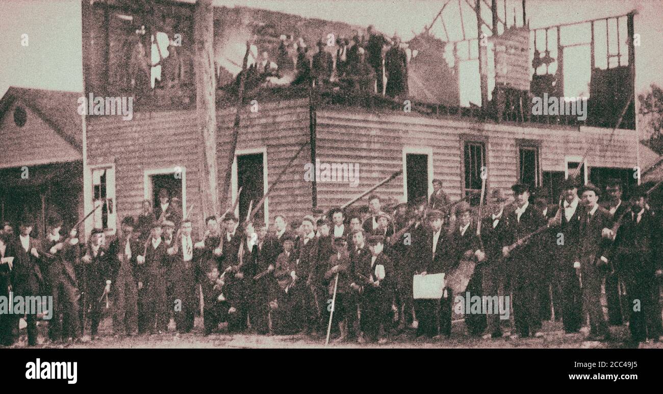 Mob posing by the ruins of The Daily Record. Wilmington, North Calolina. USA. 1898 The Wilmington insurrection of 1898, also known as the Wilmington m Stock Photo