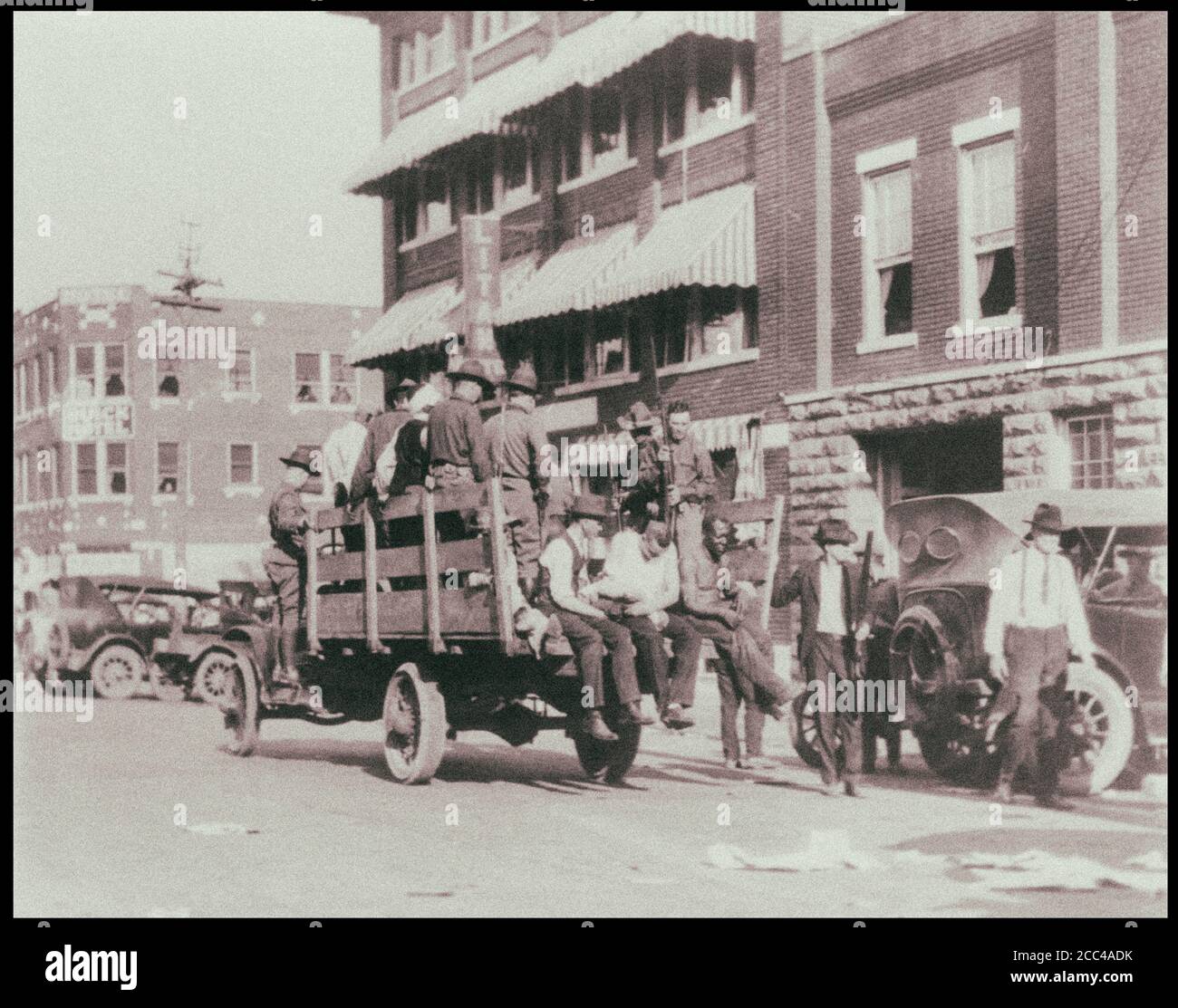 Truck on street near Litan Hotel carrying soldiers and African Americans during Tulsa race riots. Oklahoma. USA. 1921 Stock Photo