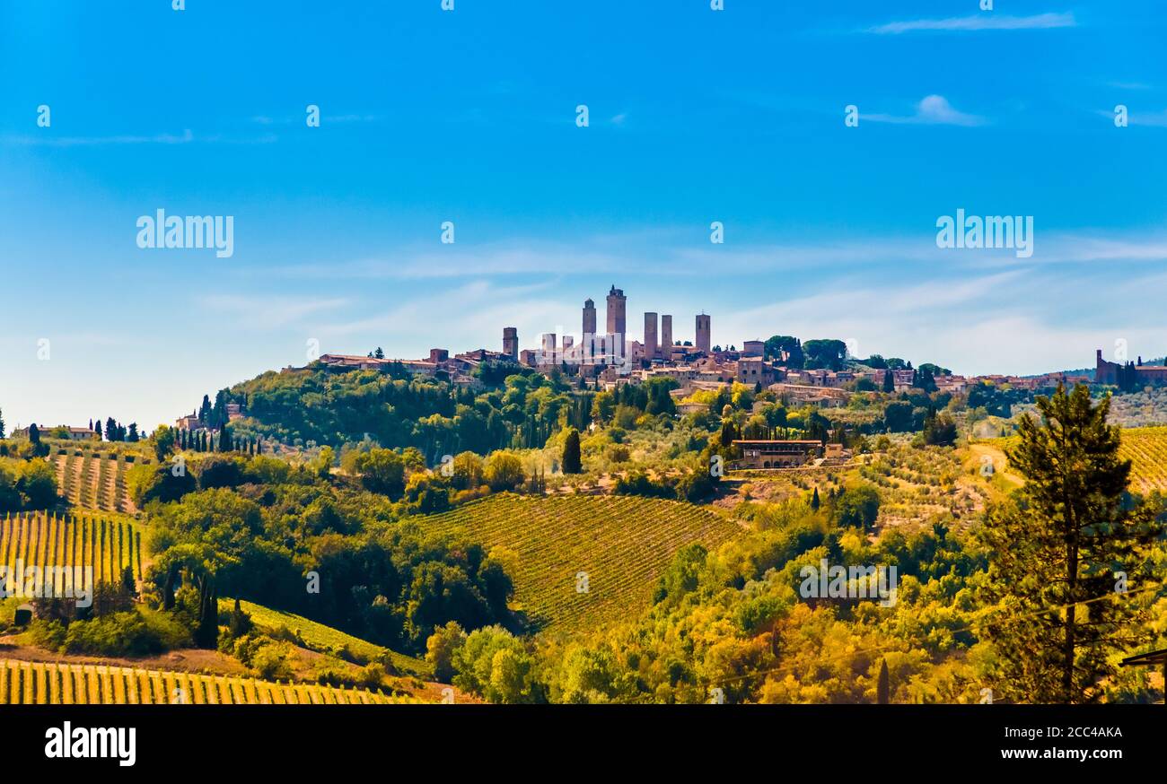 Lovely panoramic view of the famous medieval hill town San Gimignano with its stunning towers on a sunny day with a blue sky, surrounded by the... Stock Photo