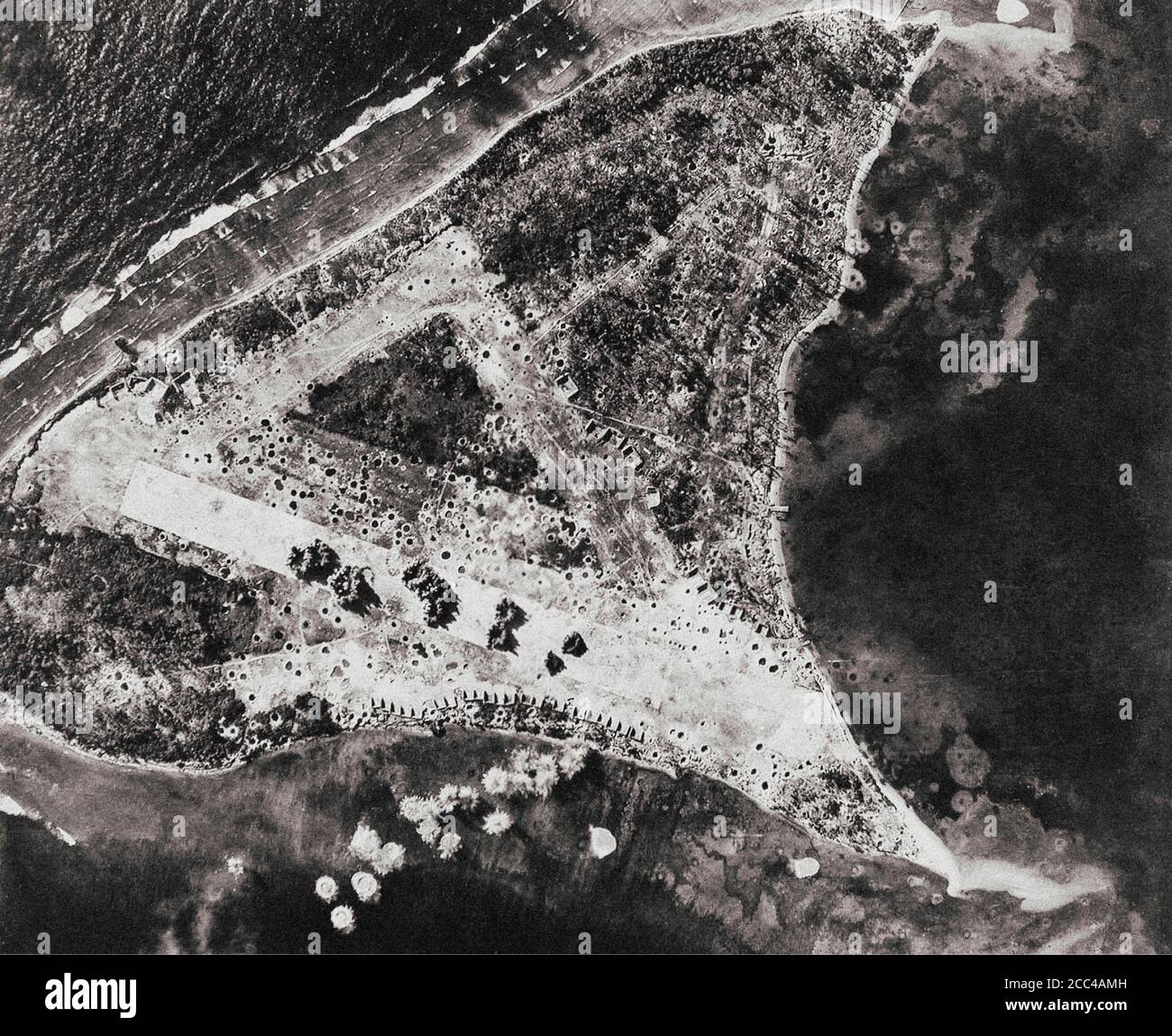 Explosions of large aircraft bombs on the Japanese runway at Woleai atoll in Micronesia. Traces of previous bombings are visible. This mission was car Stock Photo