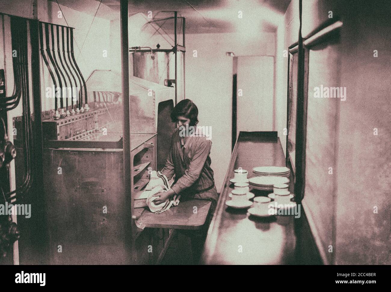 A maid prepares a dish in theHis Majesty's Airship R100’s galley. 1929. Stock Photo