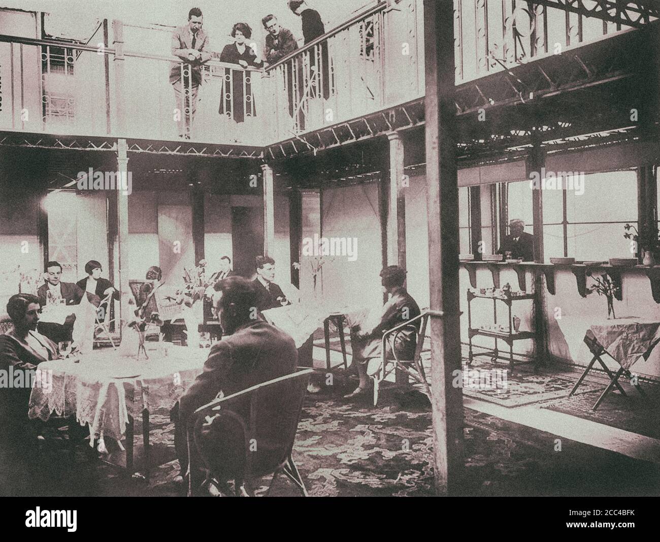 Passengers hang around the salon and upper gallery of His Majesty's Airship R100. 1930. Stock Photo