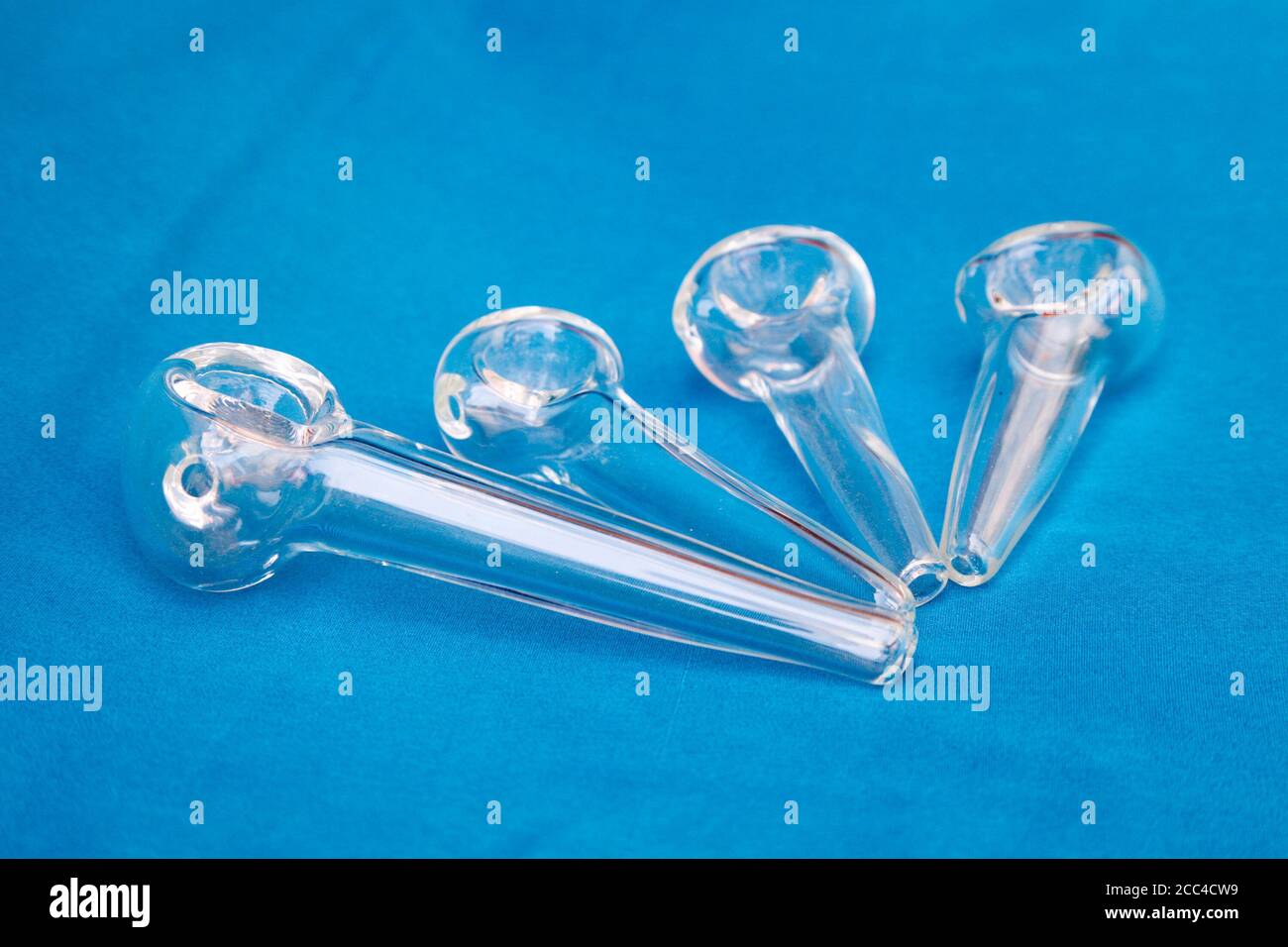Glass pipe or bong for marijuana smoking on a blue fabric background Stock Photo