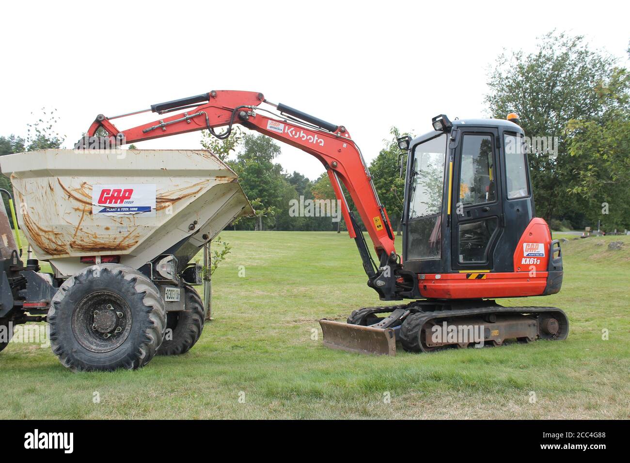 Mini digger with bucket in back of dumper truck, with copy space Stock Photo