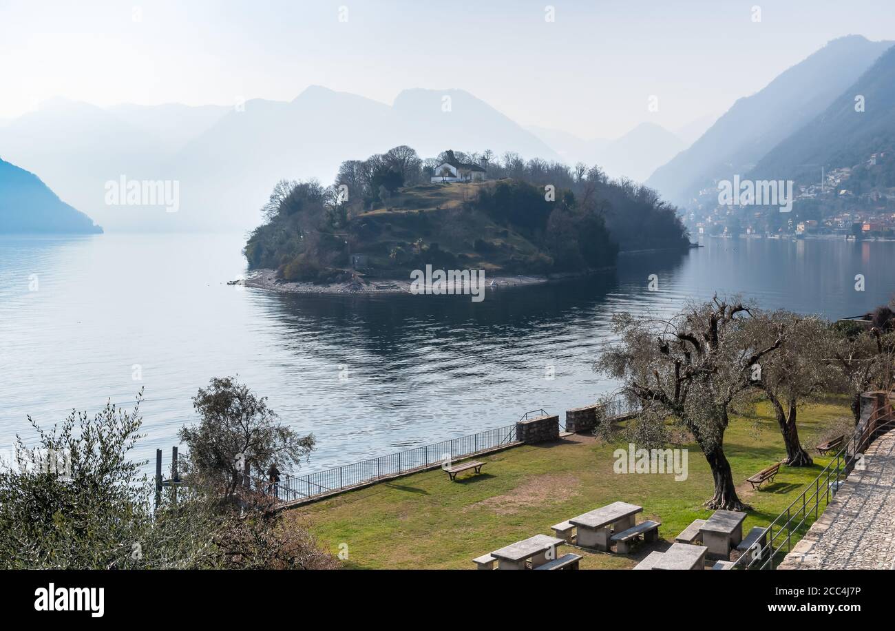 Comacina Island in the fog, surrounded by Lake Como, it is located in Ossuccio of the municipality of Tremezzina in the province of Como, Italy Stock Photo