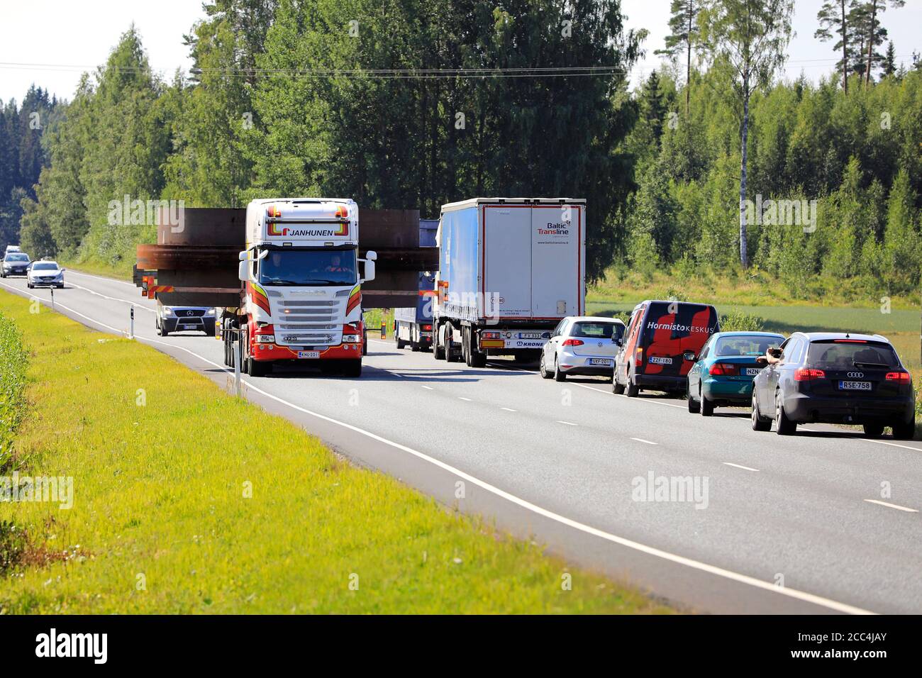 Traffic from opposite direction giving way to 7,1 metres wide oversize load transport by semi trailer of Janhunen. Urjala, Finland. August 14, 2020. Stock Photo