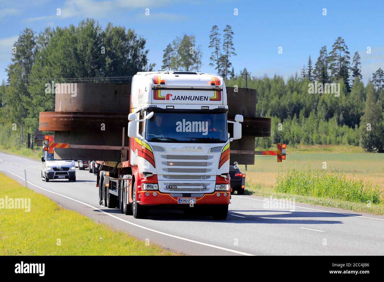 7,1 metres wide oversize load transport pulled by Scania semi trailer of Janhunen and assisted by 3 pilot vehicles. Urjala, Finland. August 14, 2020. Stock Photo