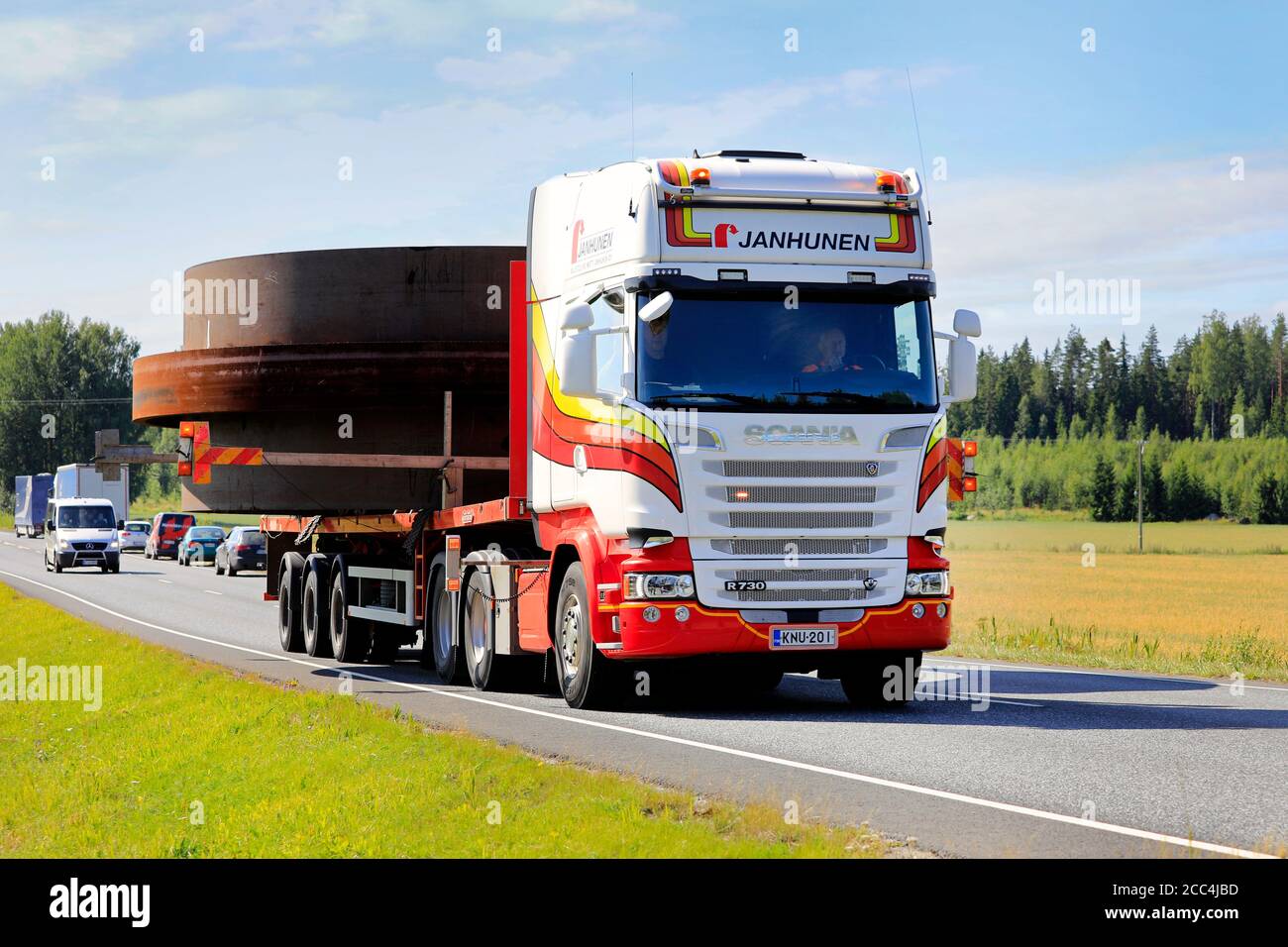 7,1 metres wide oversize load transport pulled by Scania semi trailer of Janhunen and assisted by 3 pilot vehicles. Urjala, Finland. August 14, 2020. Stock Photo