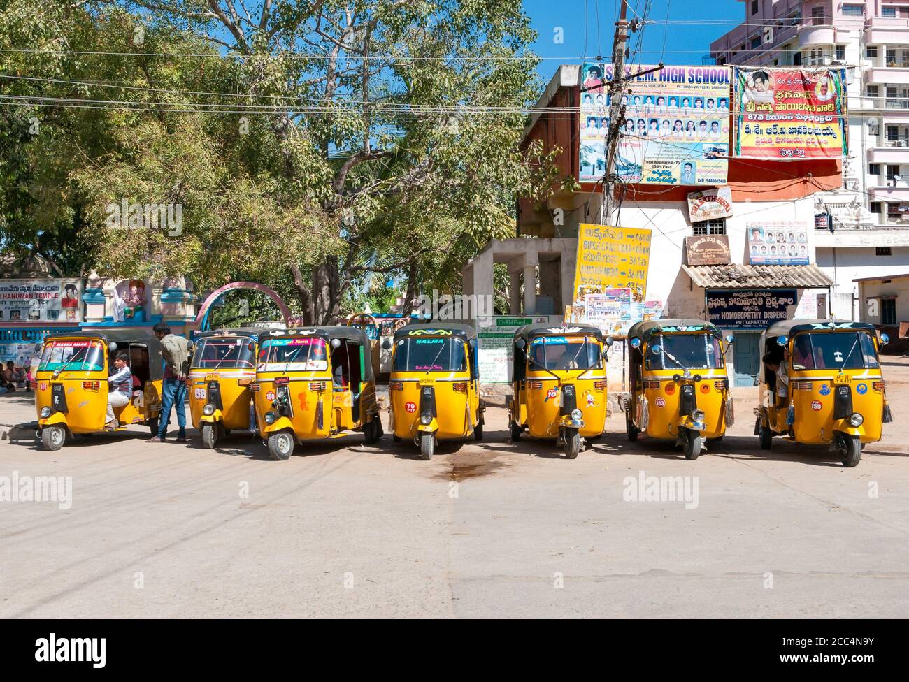 Puttaparthi, Andhra Pradesh, India - January 13, 2013: Yellow rickshaw taxis on a road in Puttaparthi village. Stock Photo