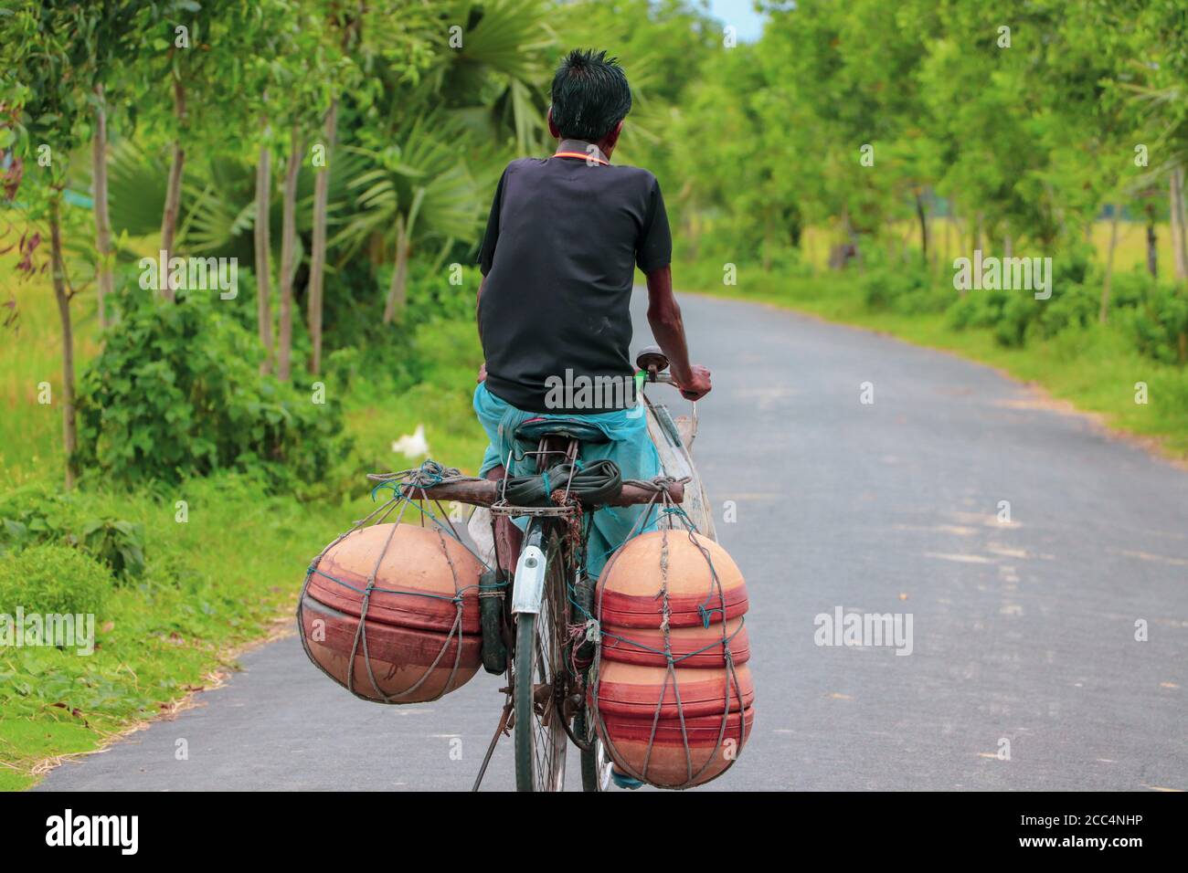 Asian street vendor carrying clay pots with his bicycle for door to door retail sale Stock Photo