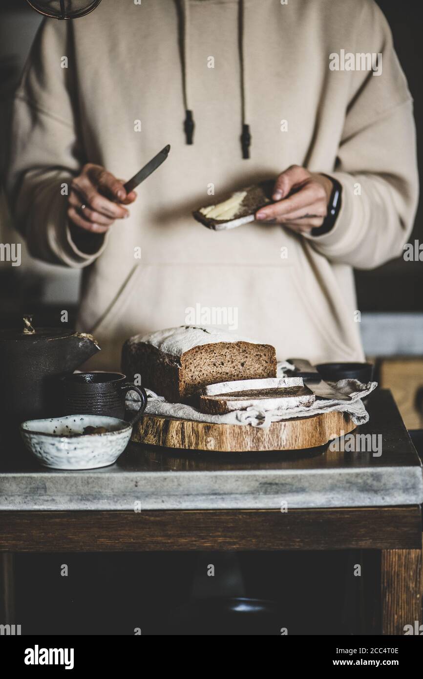 Woman spreading butter to healthy rye Swedish bread slice Stock Photo