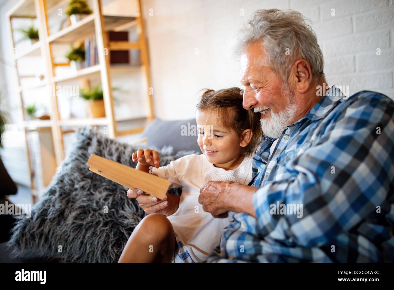 Grandparent playing and having fun with their granddaughter Stock Photo