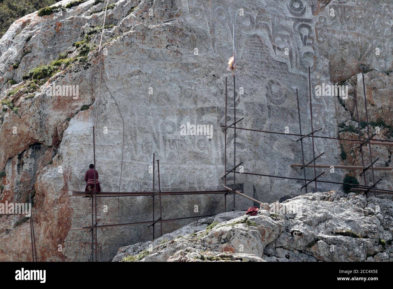 Rock carving, with carver and scaffolding, near Yushu, south Qinghai Province, China 24th August