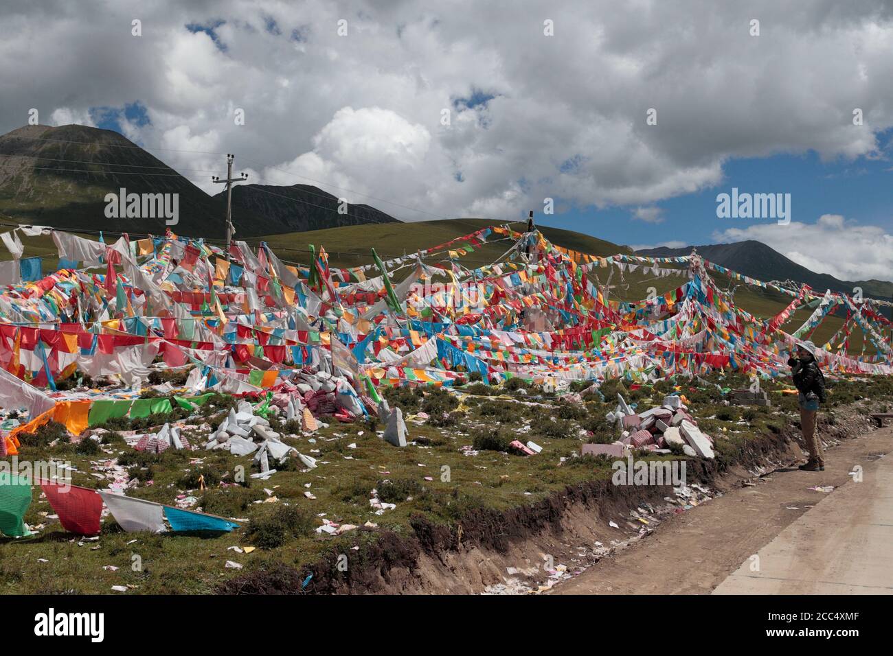 Prayer flags, prayer papers at stone at a pass, near Yushu, south Qinghai Province, China 24th August 2017 Stock Photo