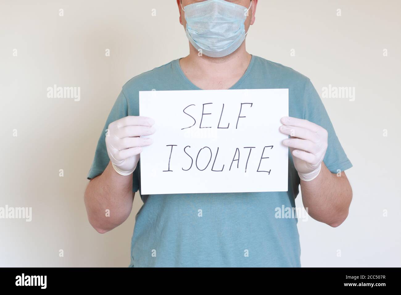 Doctor holding a Sign "Self Isolate". Stock Photo