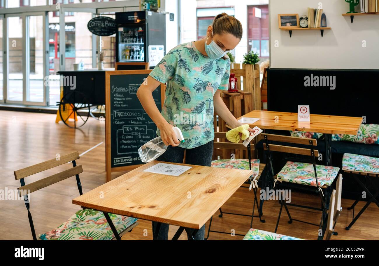 Waitress disinfecting tables in a coffee shop Stock Photo