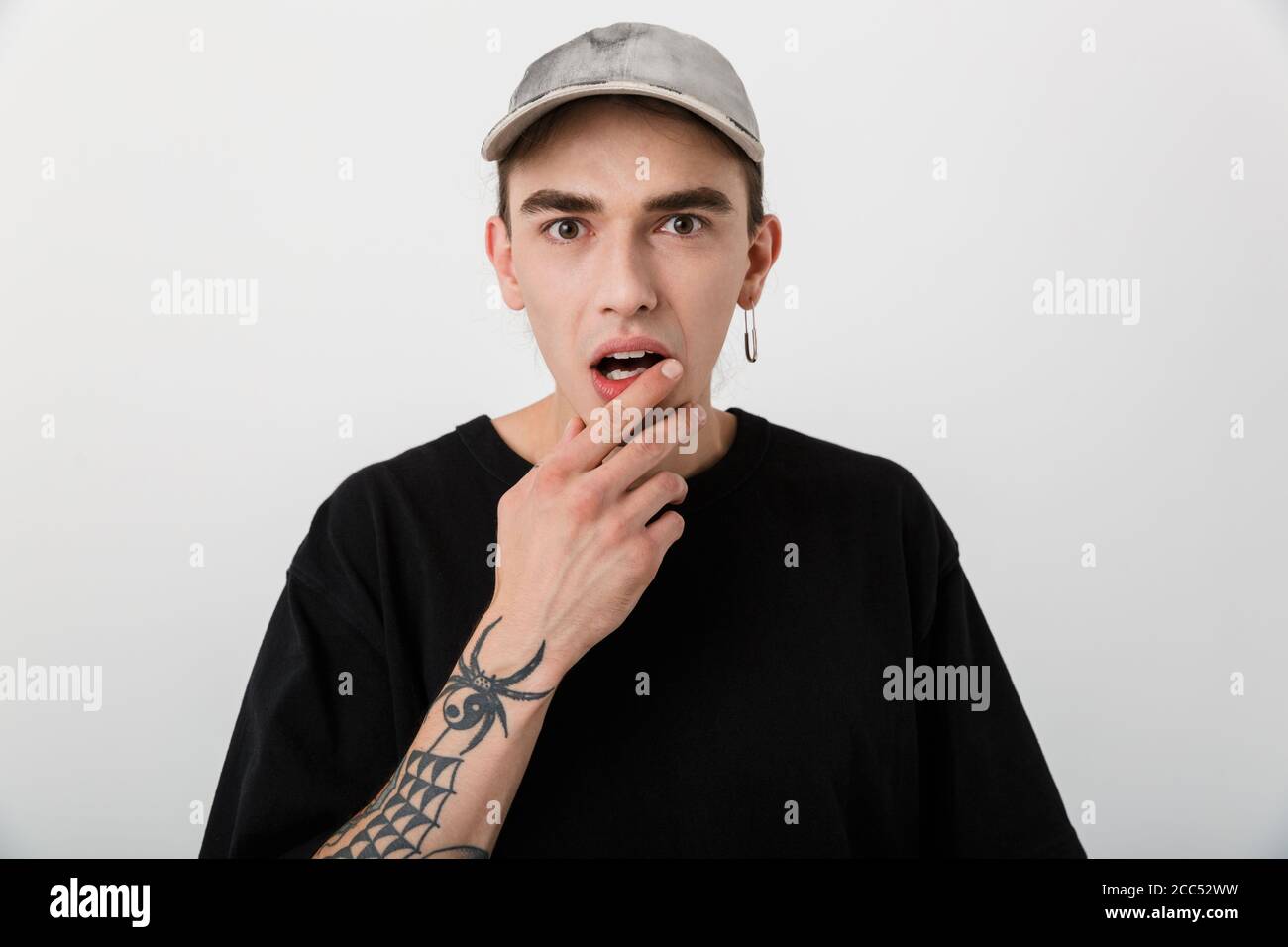 Portrait closeup of shocked young man wearing black clothes looking at