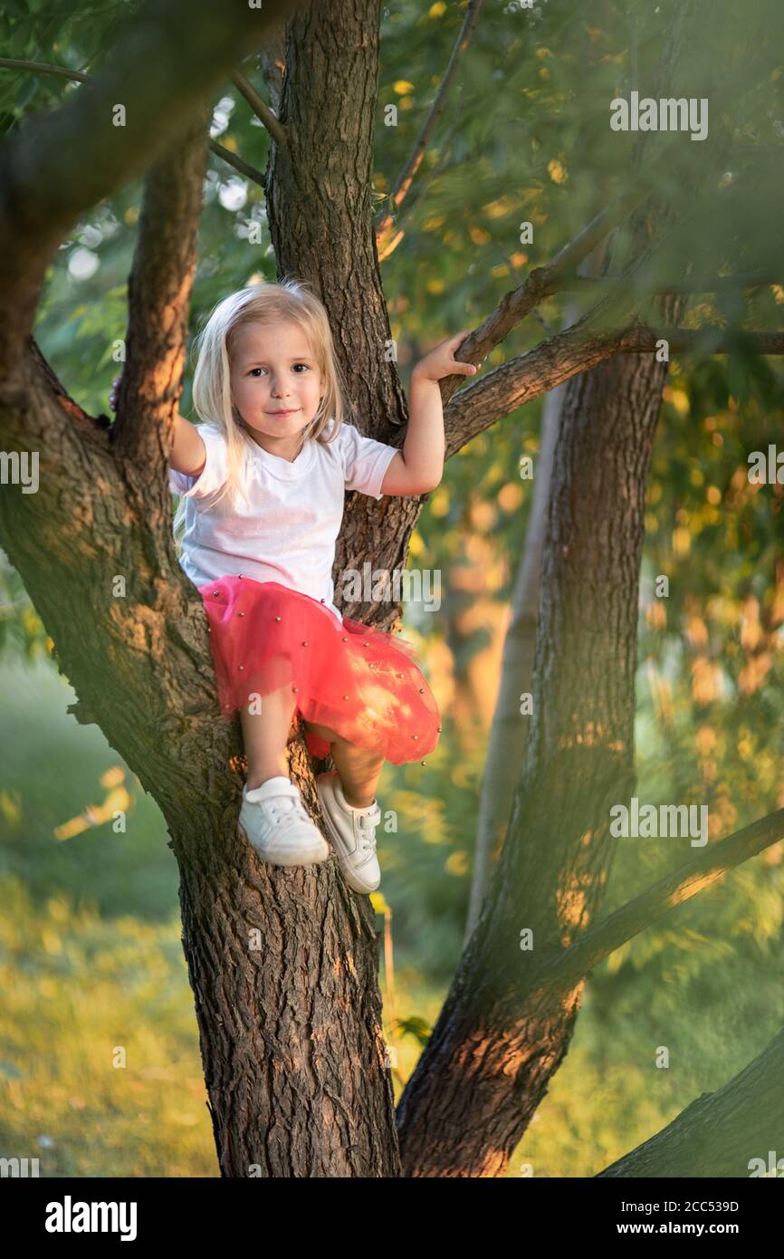 Little girl sitting on willow tree Stock Photo Alamy