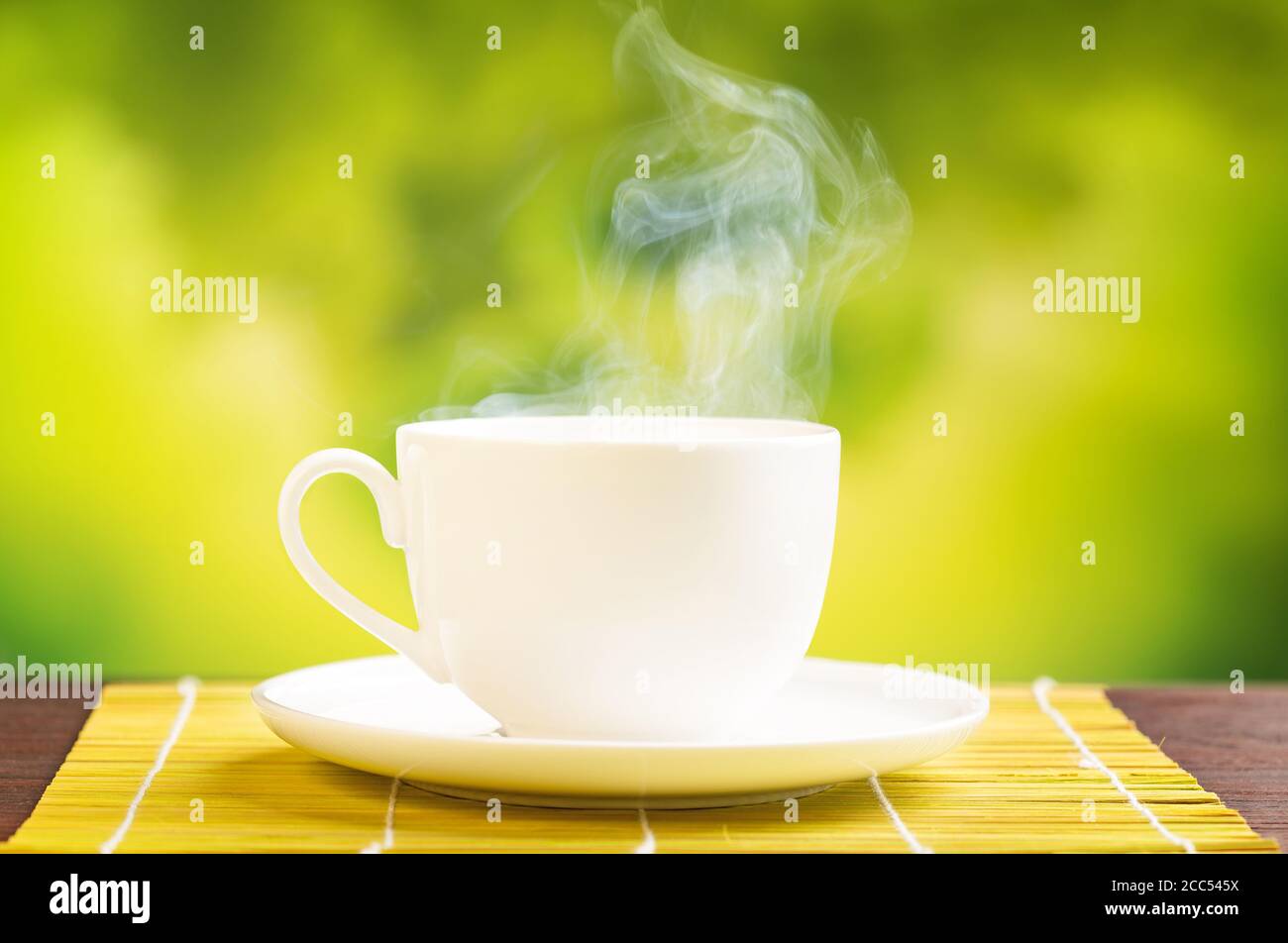 steaming hot drink in blurred green background Stock Photo