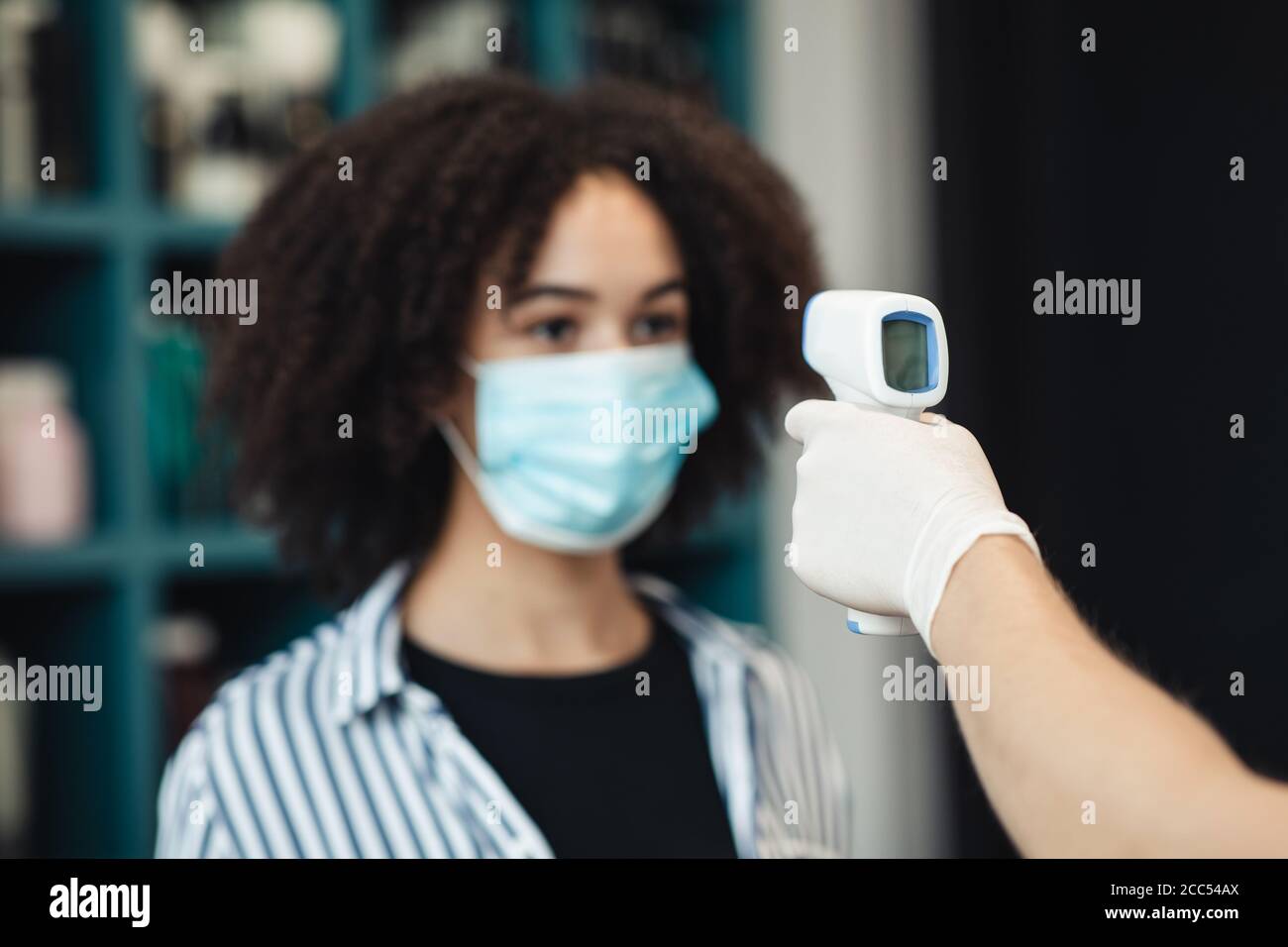 Young black woman in medical mask getting thermal screening Stock Photo