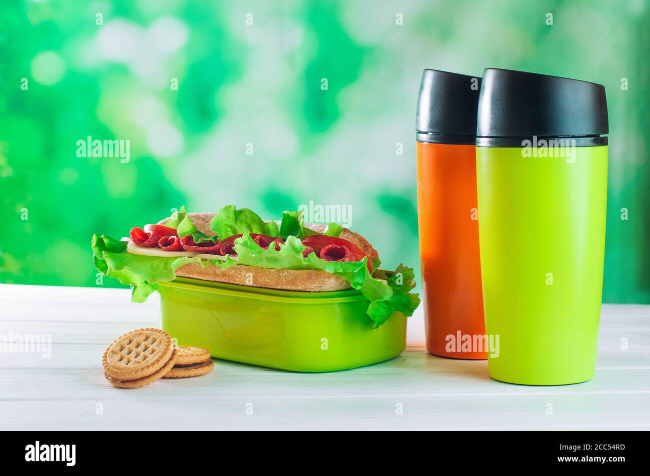 https://c8.alamy.com/comp/2CC54RD/color-thermos-mugs-near-lunch-box-on-the-white-wooden-table-2CC54RD.jpg