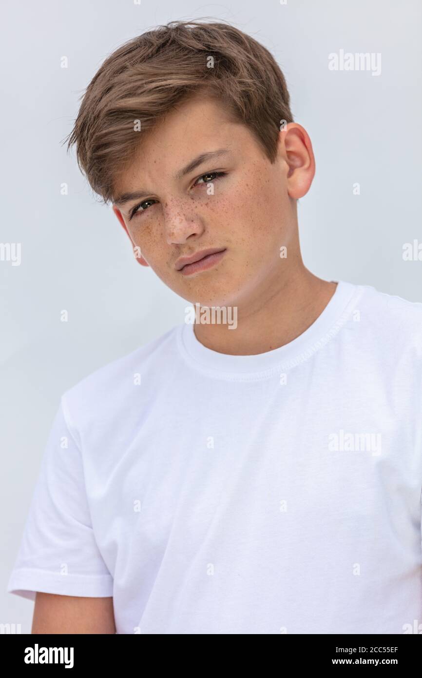 White background studio portrait of a boy teenager teen male child wearing a white t-shirt Stock Photo