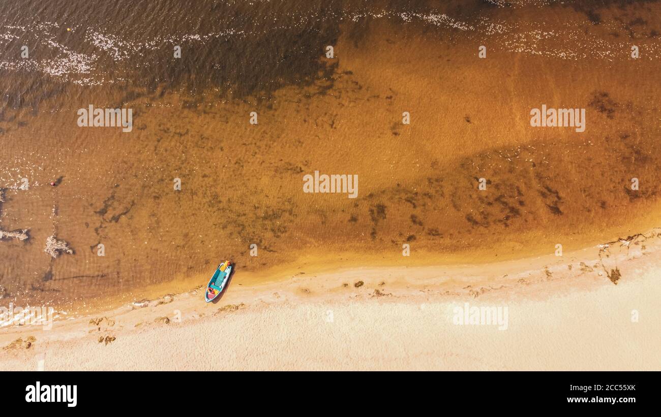 Aerial view on coastline. Summer seascape with clear water in sunny day. Top view of boat from drone.  Stock Photo