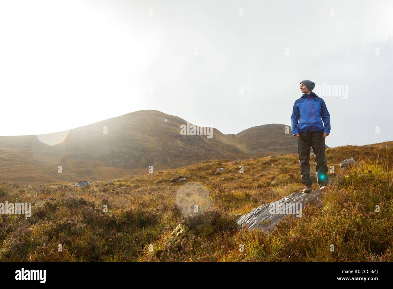 A person walking in Scottish countryside near the Allt Coire Rooill river in Torridon, Scotland Stock Photo