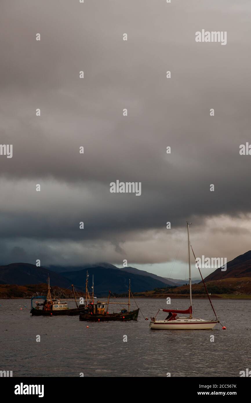 Boats anchored in Loch Broom with a storm overhead, Ullapool, Scotland Stock Photo