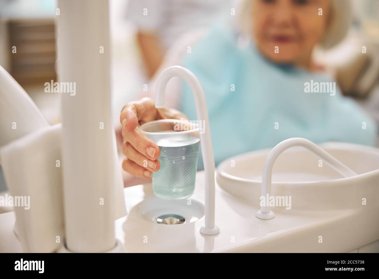 Elderly woman holding plastic cup with water Stock Photo Alamy