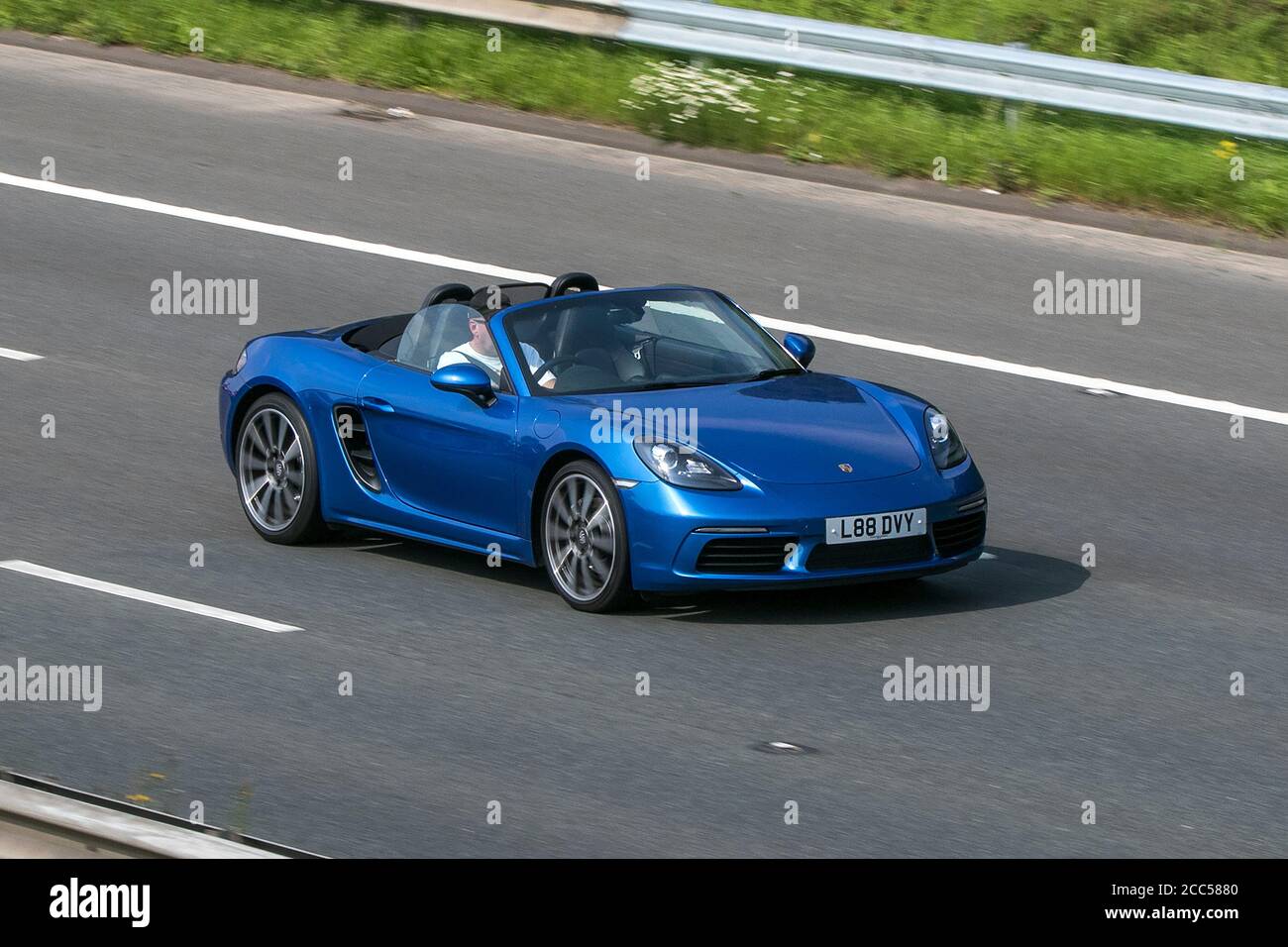 L88DVY 2018 Porsche 718 Boxster Blue Car Roadster convertible cabriolet roof down driving on the M6 motorway near Preston in Lancashire, UK. Stock Photo