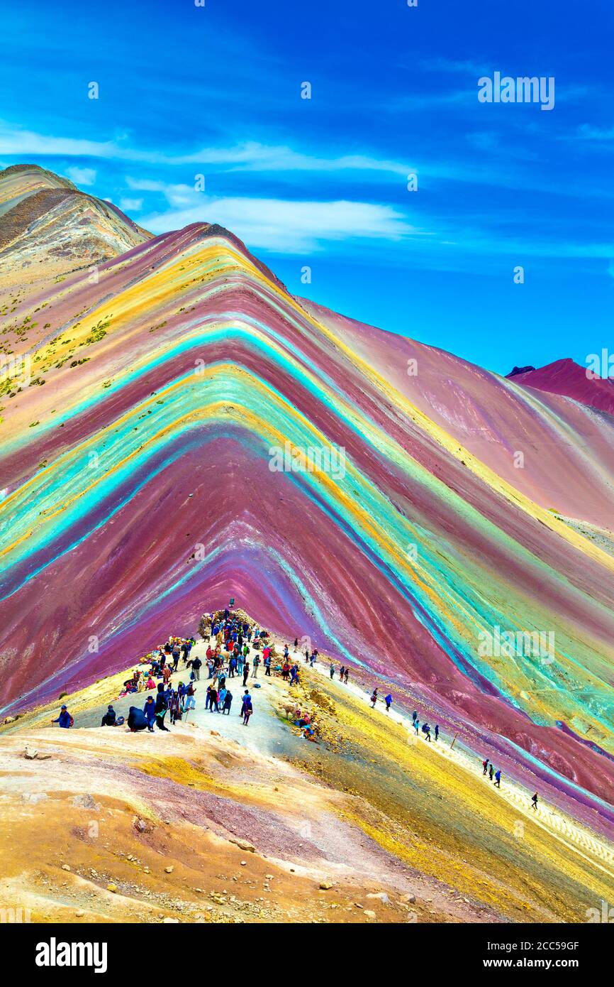 Tourists hiking up Vinicunca (Rainbow Mountain) in Pitumarca, Peru Stock Photo