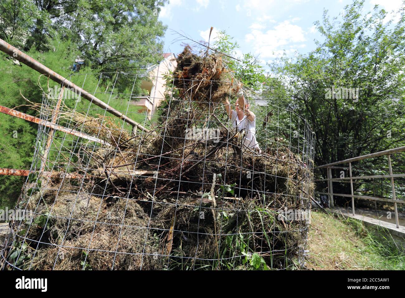 Organic composter. People are making bio composter bin in a yard. Stock Photo