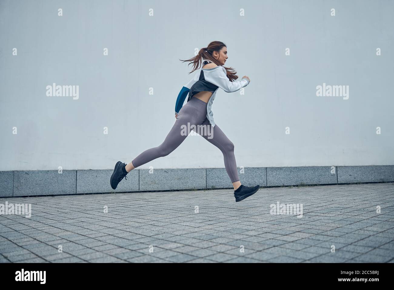 Fit young Caucasian lady moving in midair Stock Photo