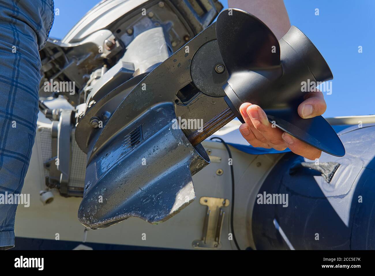 man changing propeller on outboard motor. Repairing outboard motor for