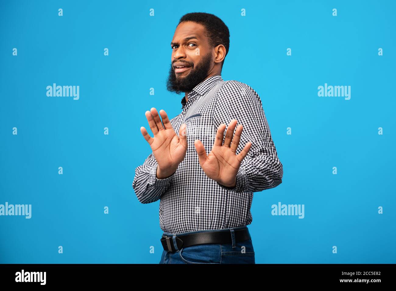 Shocked black man with disgusted face at blue studio Stock Photo - Alamy