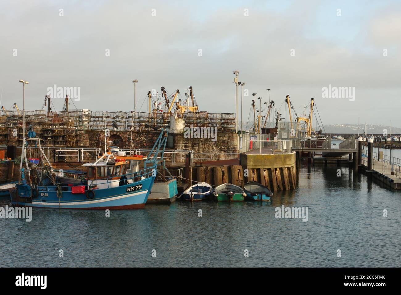 Fishing boat moored alongside quay in harbour, Brixham, Devon, UK Stock ...