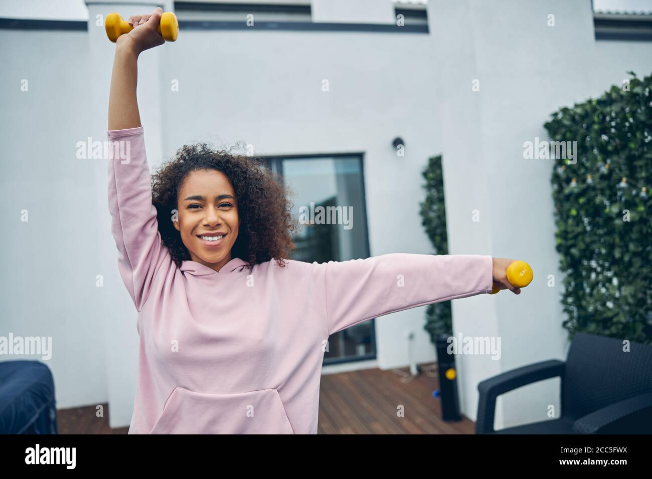 Attractive female with curly hair doing exercise Stock Photo Alamy