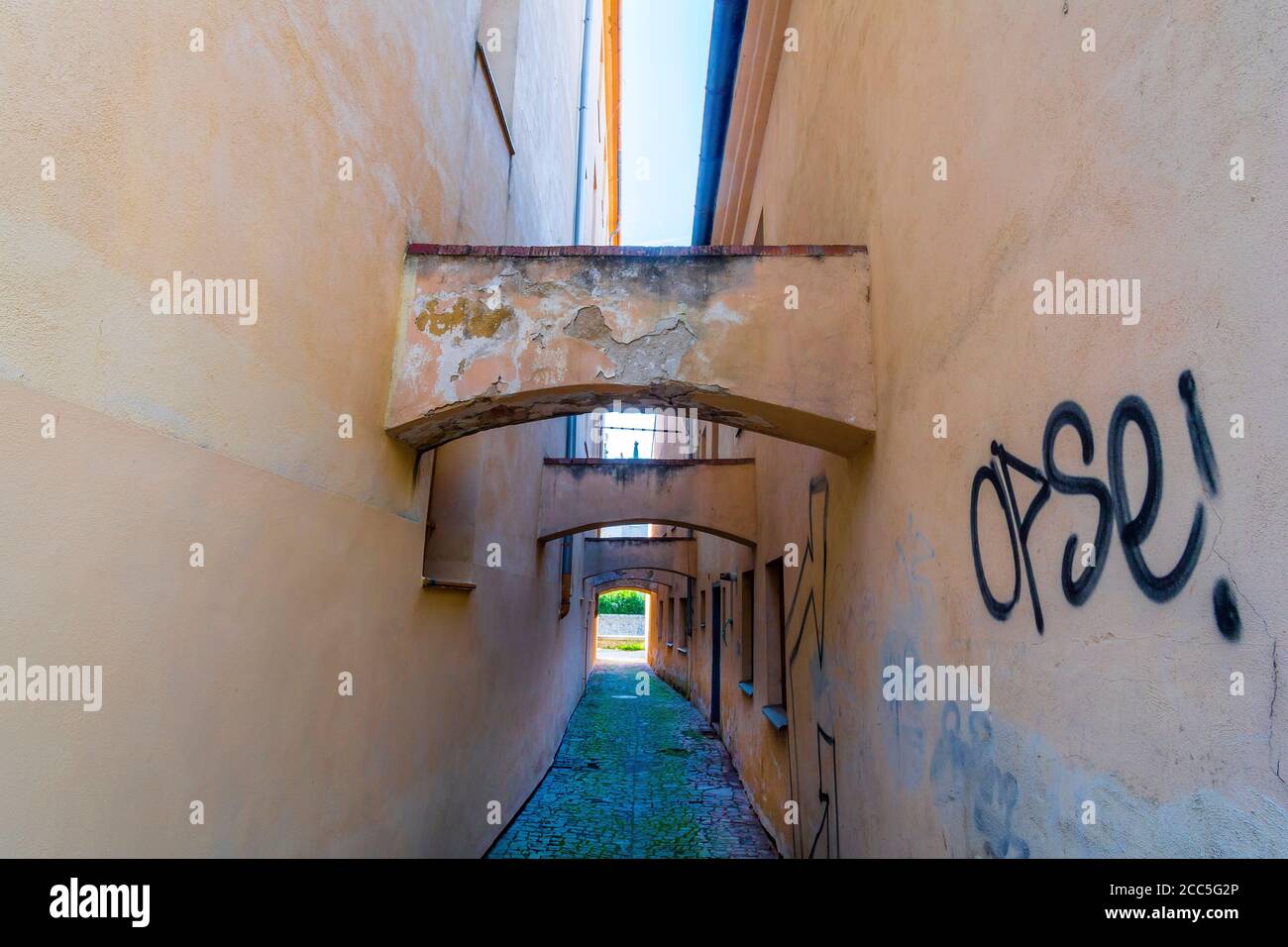 narrow street spanned with arches in the Jewish Quarter of Třebíč, one ...