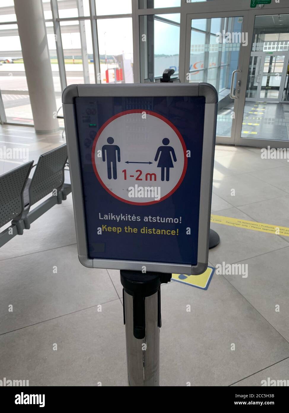 Social distancing sign at Vilnius airport. Passengers have to keep 1-2 meters distance to protect from corona virus spreading. Vilnius / Lithuania. Stock Photo