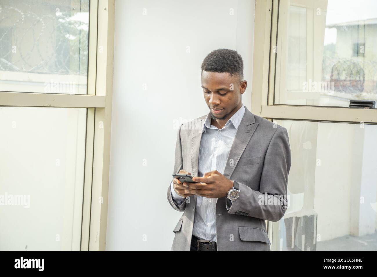 Young black businessman using his mobile phone Stock Photo