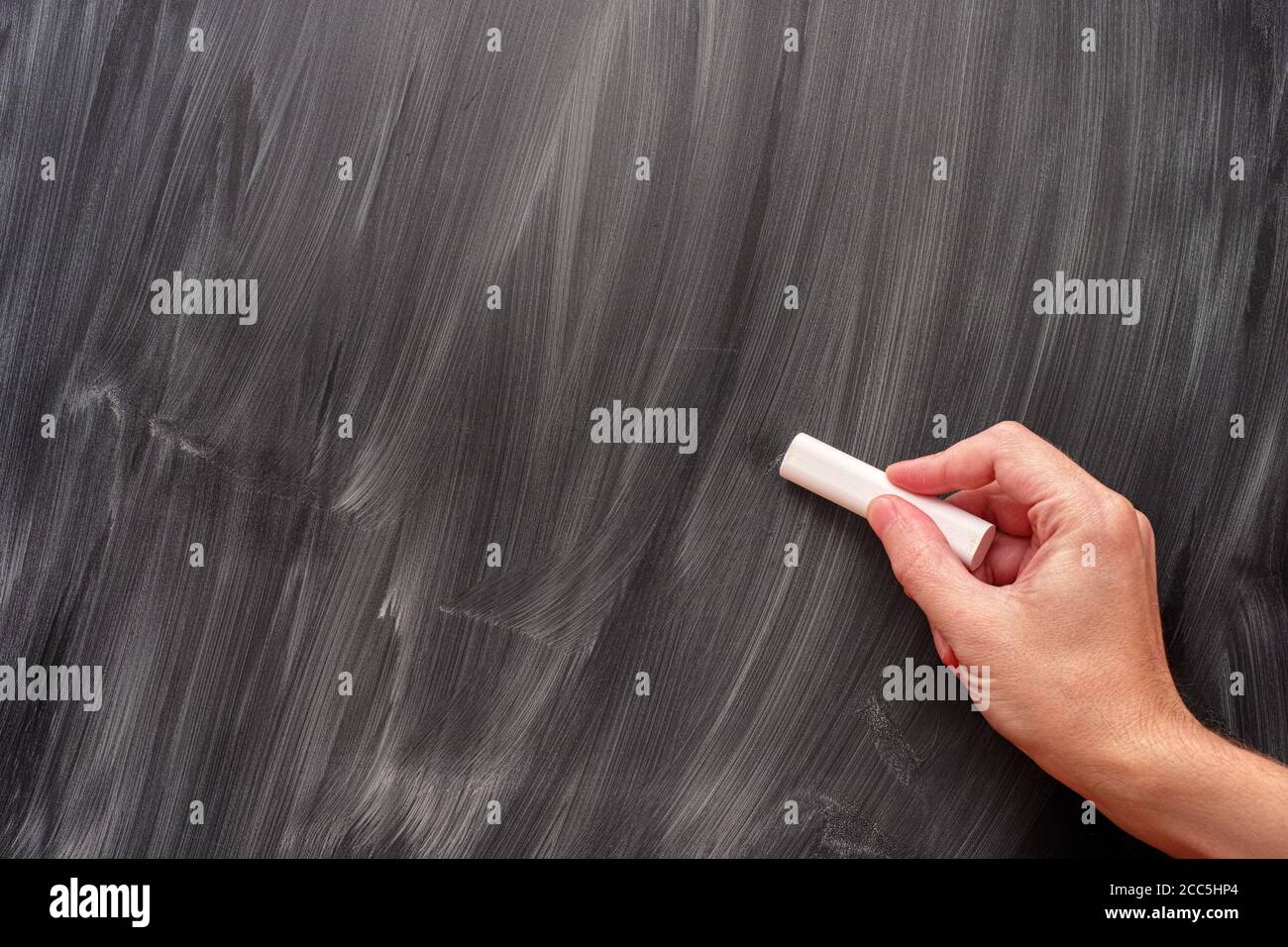 Person using white chalk on a blackboard. Close up Stock Photo Alamy