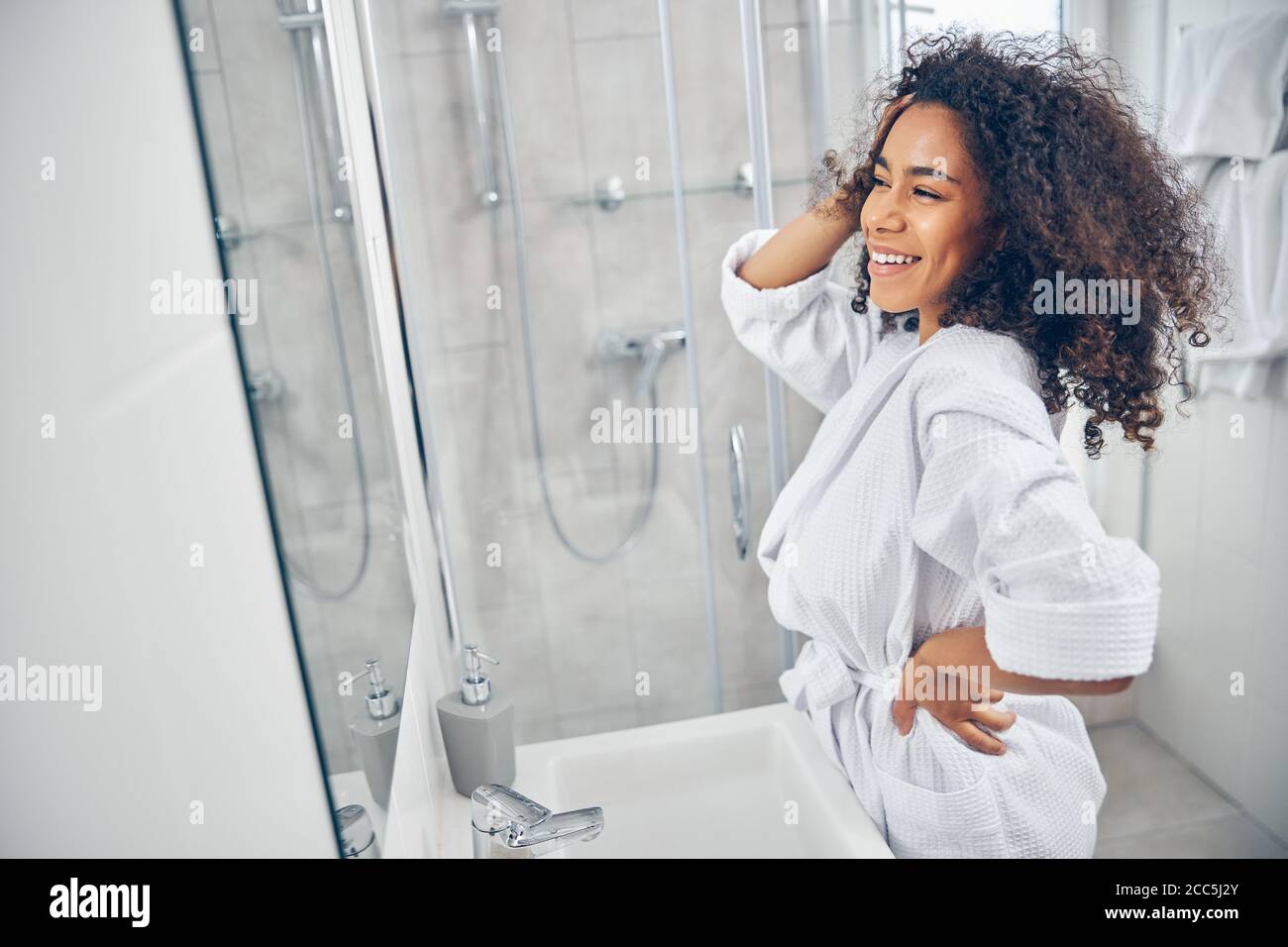 Happy young woman standing in the bathroom Stock Photo